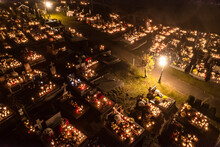 Atmospheric Drone Aerial View Of Beautifully Illuminated Graves In Cemetery Decorated With Flowers. All Saints' Day In European City. High Quality Photo