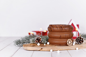 Wall Mural - Traditional German layered winter cake showing layers inside called 'Baumkuchen' glazed with chocolate, surrounded by seasonal decoration