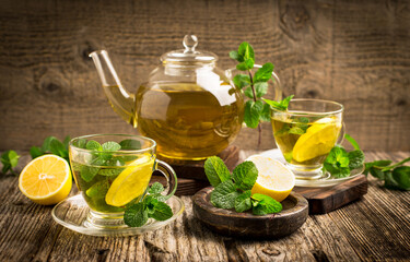 Wall Mural - Fresh mint tea with lemon on the wooden table
