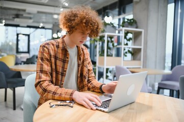 Excited overjoyed young business man student winner looking at laptop celebrate bet bid win online success victory new opportunity sit at cafe table, read good internet email news, got new job offer