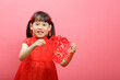Chinese girl with traditional dressing up hold a Fu means 'lucky' greeting  sign  against pink background