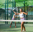 Woman padel tennis player training on court. Woman using racket to hit ball.