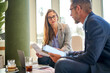 © Cavan Images - Two colleagues sitting in a cafe, having an informal business meeting