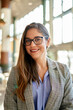 © Cavan Images - Portrait of young businesswoman standing in big office.