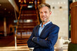 © Cavan Images - businessman standing in big office and looking at camera while smiling