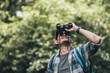 © Charnchai saeheng - Hikers use binocular to see animals and view landscape  with backpacks in the forest. hiking and adventure concept.