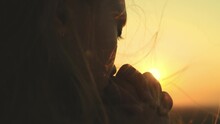 Girl Prays Looking Sunset, Long Hair Flying Away In Glare Sunlight Rays Strong Wind, Looking At Dawn, Lonely Hike Of Brave Girl, Looking Into Sky With Her Eyes, Believing Good. Close-up Hands Face.