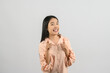 © Johnstocker - Portrait of Young asian woman in pink shirt pointing finger at camera isolated on white background