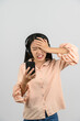 © Johnstocker - Portrait of Young asian woman with headphone expressing surprise while using mobile phone isolated over white background