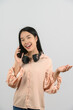 © Johnstocker - Portrait of Young asian woman with headphone talking on mobile phone isolated over white background