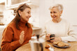 © shurkin_son - Cozy scene of two old friends having nice chat at cafe, enjoying tea or coffee, discussing latest news. Cheerful senior female telling interesting story during breakfast with her stylish female friend