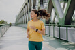 © Halfpoint - Young woman jogging at city bridge, healthy lifestyle and sport concept.