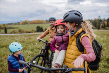 Young Family With Little Children Preparing For Bicycle Ride In Nature. Healthy Lifestyle Concept.