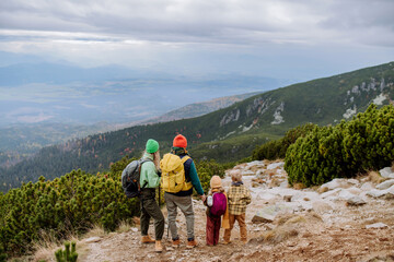 Wall Mural - Happy family hiking together in autumn mountains.