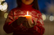 © Natalia - burning candle in hands of child for christmas at home