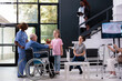 © DC Studio - Granddaughter handing bouquet of flowers to disabled grandfather after finishing medical consultation in hospital waiting area. Elderly man discussing health care treatment with nurse
