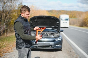 Wall Mural - A young man with a black car that broke down on the road,copy space.