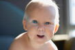 Portrait of a happy baby with blue eyes close-up. White hair illuminated by counter light