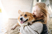 Blond Woman Laughing And Holding Cute Dog Sticking Out Tongue