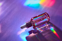 Cosmetic Product Bottle With Iridescent Highlights On Holographic Background. Skincare Beauty Product Concept