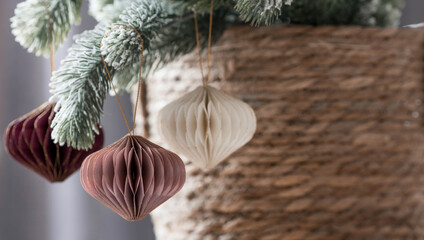 stylish paper christmas tree toys in scandinavian style on fir branches. beige tones. banner for des