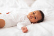 © Prostock-studio - Little Cute African American Baby Lying On Bed And Looking At Camera