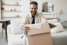 Happy Young Man Opening Parcel At Home, Handsome Guy Open Package Indoor, Delivery, Shipment, Satisfied Customers Concept