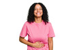 © Asier - Young cute brazilian woman isolated touches tummy, smiles gently, eating and satisfaction concept.