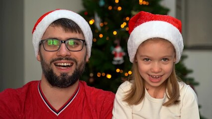 Wall Mural - Happy family, father and little girl throw snow on background of shining Christmas tree at home and laugh. New year and christmas celebration