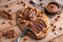 Board Of Bread With Chocolate Paste And Hazelnuts On Wooden Background