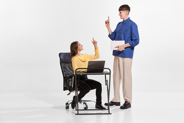 Wall Mural - Portrait of two people, employees, man and woman helping each other, giving advice isolated over white background