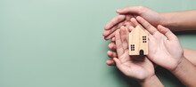 Hands Holding Wooden House, Family Home, Homeless Housing, Mortgage Crisis And Home Protecting Insurance, International Day Of Families, Foster Home Care, Family Day Care, Stay Home Concept