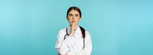 Young Female Doctor, Hospital Worker In White Coat, Thinking And Looking Away Thoughtful, Searching Solution, Standing Over Toquoise Background