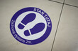Aufkleber am Boden eines Einkaufszentrums in Polen mit den Worten: Stan Tutaj Zachowaj dystans 2m. Übersetzung: Halten Sie einen Abstand von 2 m ein