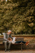 © BGStock72 - Grandfather spending time with his granddaughter on bench in park on autumn day