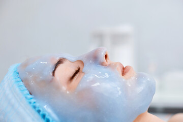 beautiful woman with blue alginate mask on face