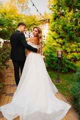 Wall Mural - newlyweds. groom and bride in traditional wedding clothes walk in park