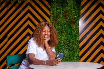 Wall Mural - Beautiful cute young woman in the cafe, using mobile phone