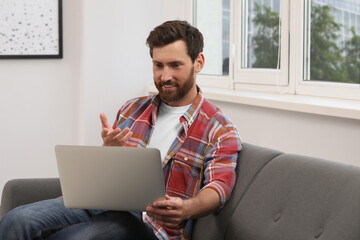 Poster - Bearded man having video chat on laptop indoors