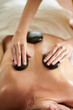 © DragonImages - Masseuse Placing Hot Stones on Back