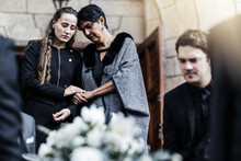 Funeral, Senior Mother And Woman Sad, Crying And Death In Family, Church And Grief For Loss Of Life. Young Female Comfort, Care And Support Elderly Mom After Ceremony Or Service Outdoor A Chapel