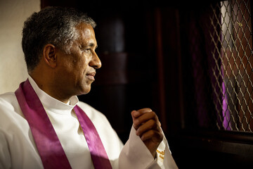 Religion, church and priest in confession booth listening to people confess, share and speak about their sins, mistakes and ask forgiveness. Christianity, catholic tradition and man ready to listen