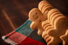 Homemade Smiling Gingerbread Man Cookie Peeking Out From A Row Of Cookies. Standing Out From Crowd Concept