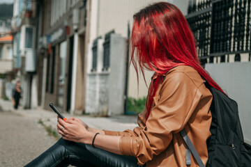 Wall Mural - young woman with backpack and mobile phone on the street