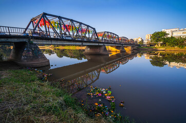 Wall Mural - Reflection of Iron Bridge and colorful light lantern in sunrise. Loi Krathong or Yi Peng Festival in Chiang Mai, Thailand.