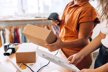 Wall Mural - Clothing store owner scanning a parcel box in a shop