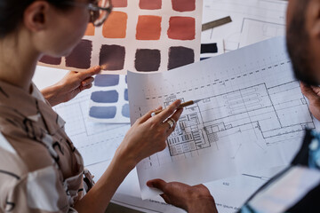 Wall Mural - Close up of two architects discussing floor plans and color swatches for interior design project