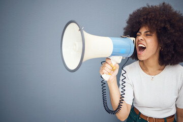 Studio, megaphone and angry black woman shouting and protesting for change, freedom or democracy. Loudspeaker, bullhorn and speech of young female using voice, screaming in protest for justice.