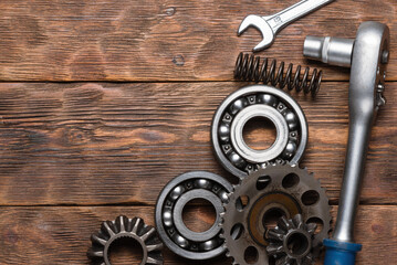 Wall Mural - Car spare parts, gear wheels and wrenches on the wooden workbench flat lay background with copy space.