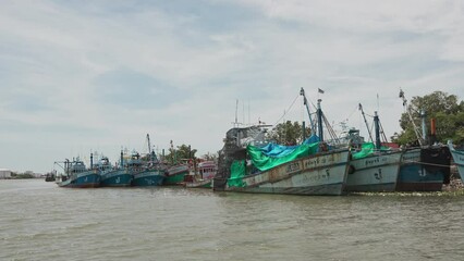 Wall Mural - Sailing through fishing boats moored on the shore of the pier